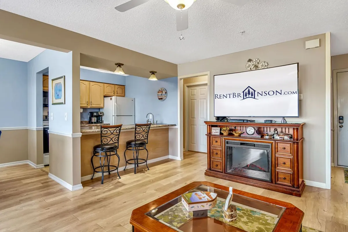 The photo captures the open-concept kitchen, dining, and living area as seen from the entryway or hallway. The sightlines are clear, with a direct flow into the heart of the home, emphasizing the open layout and ease of movement through the condo.
