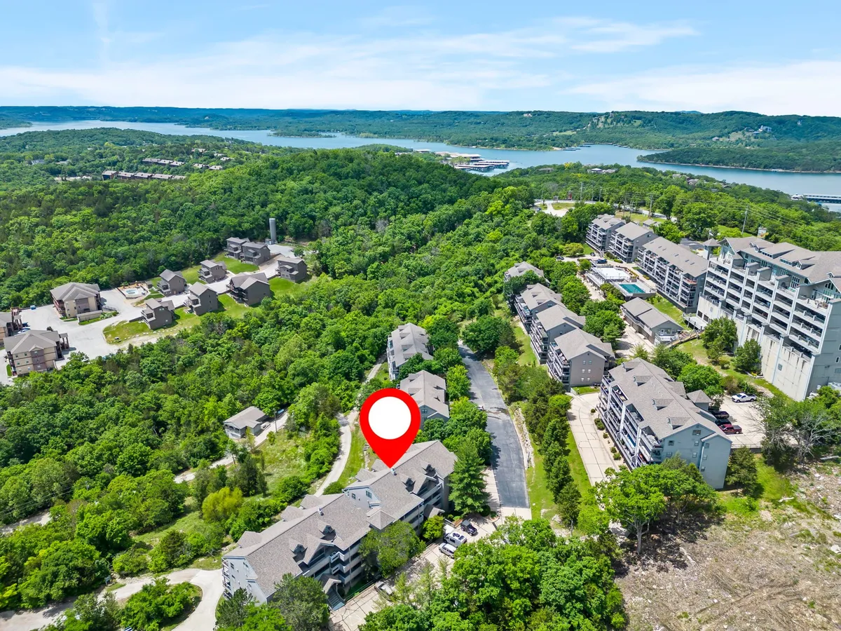A serene scene of lush greenery meeting the water’s edge, with residential buildings in the background. The peaceful lakeshore beckons for strolls, boat rides, or simply enjoying nature’s beauty at the water’s edge.